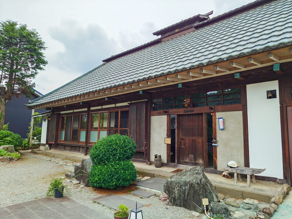 カフェ鐵馬厩の外観。瓦屋根と白壁の古民家が広がる