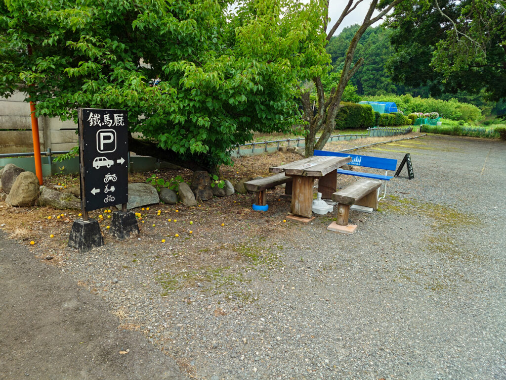 カフェ鐵馬厩の駐車場案内板。車は右、バイクと自転車は左と示されている