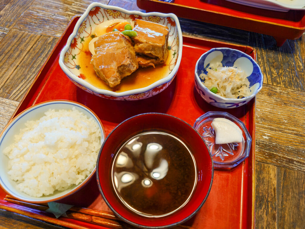 カフェ鐵馬厩の角煮定食。赤いトレイに角煮・ご飯・味噌汁・小鉢・漬物が揃う